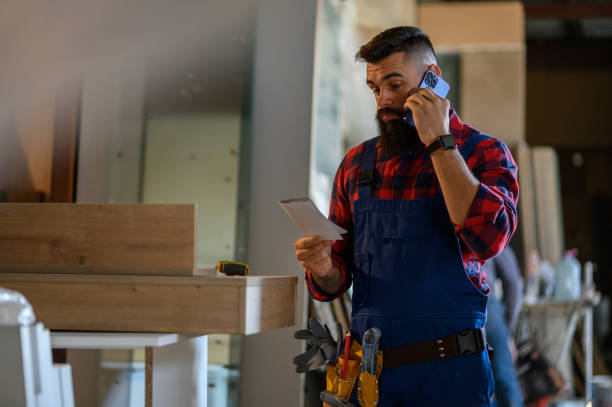 istock Young male carpenter working in workshop and using smartphone 1365037595