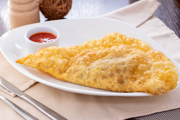 istock big gold cheburek with ketchup on white plate 1365038798
