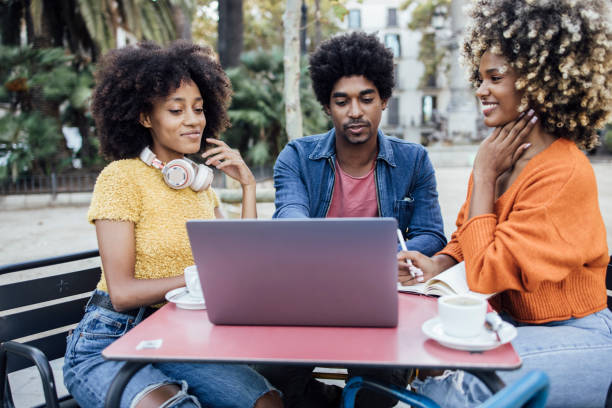 istock Three Afro friends in Barcelona sitting at the cafe  and studying 1365039005