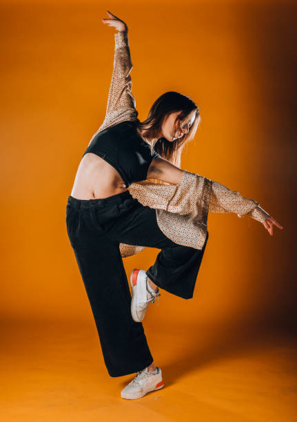 istock Stylish contemporary dance isolated on orange background 1365040326