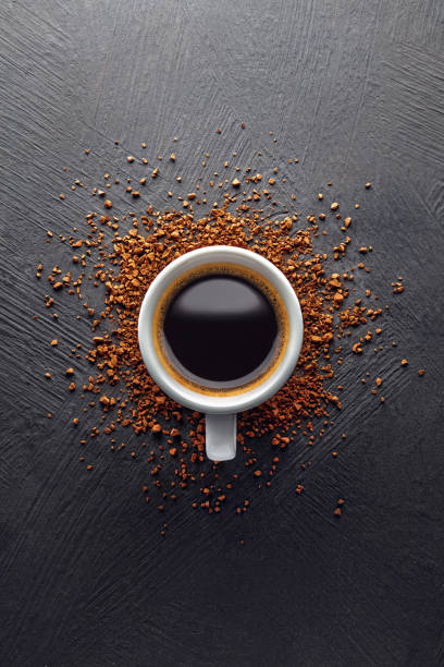 Coffee cup and instant powder on black background Coffee cup and instant powder on black textured background instant coffee stock pictures, royalty-free photos & images