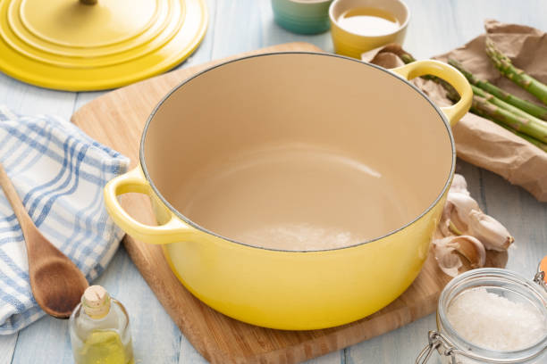 pote de ferro fundido esmaltado em uma mesa de madeira - saucepan - fotografias e filmes do acervo