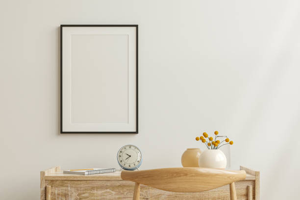 istock Mockup frame on work table in living room interior on empty white wall background. 1365054954