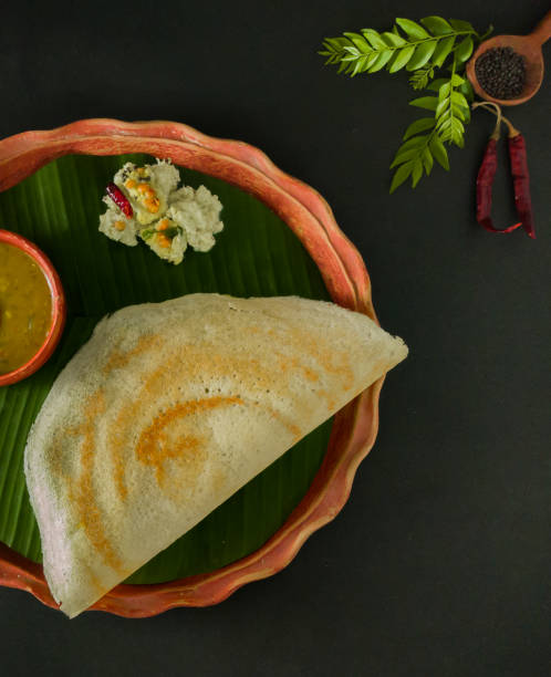 traditional south indian food masala dosa, sambar and coconut chutney served on clay plate and banana leaf. studio shot. traditional south indian food masala dosa, sambar and coconut chutney served on clay plate and banana leaf. studio shot. copy space background. thosai stock pictures, royalty-free photos & images