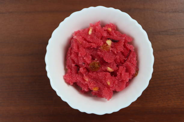 Sooji beet root halwa is a Sugar beet-Semolina based sweet dessert pudding from India. Garnished with Cashew/almond nuts and Served in a bowl, festival food