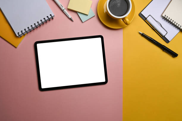istock Digital tablet with blank screen and supplies on colorful background. Top view. 1365067178