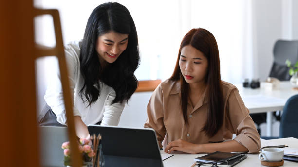 istock Two young business colleagues analyzing investment data on computer tablet together. 1365067806