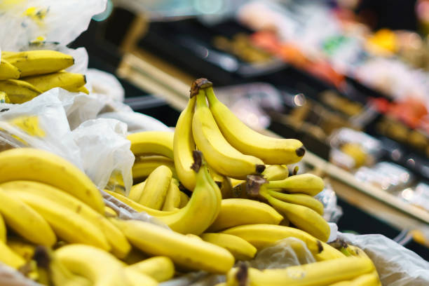식료품 슈퍼마켓의 선반에 노란색 바나나. 과일 판매 - banana bunch yellow healthy lifestyle 뉴스 사진 이미지