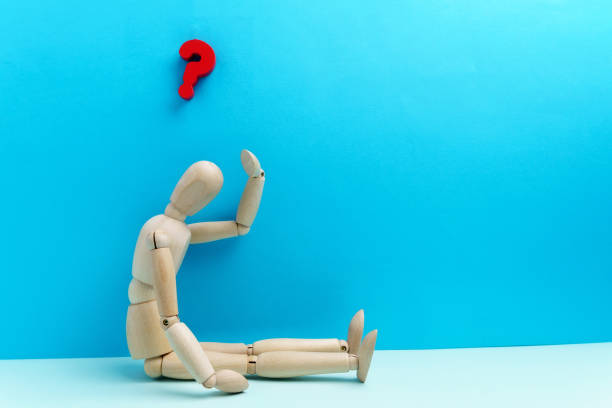istock Wooden human mannequin on a blue background with a question mark with space for copying text. 1365068851