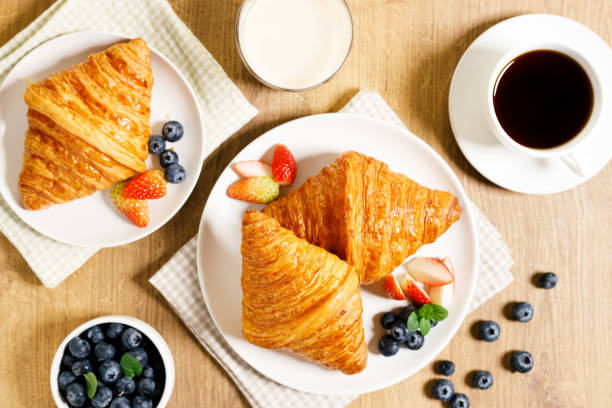istock breakfast with croissants and fresh berries on wooden table. 1365069026
