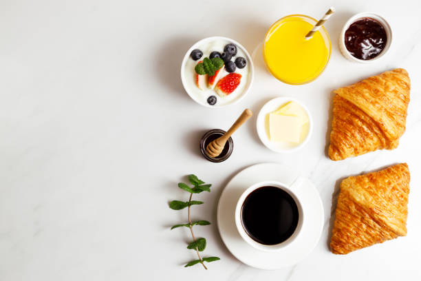 istock Breakfast with croissants, fresh berries yogurt and coffee on white table. 1365069029