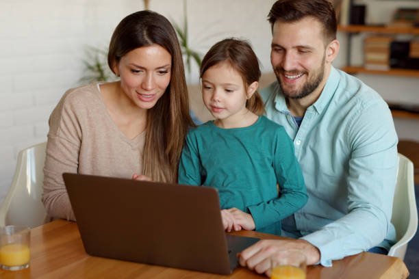 istock Happy family using laptop and making video call at home 1365071789