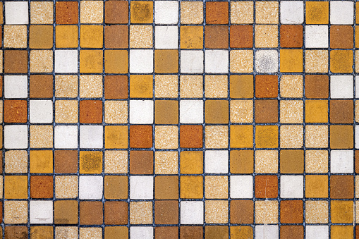 Background from a wall of brown, beige and ocre mosaic tiles