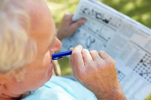 Senior man reading newspaper outside