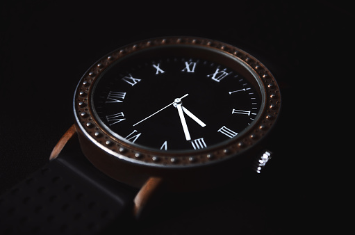 Men's accessory. Clock with Roman numerals on a black background