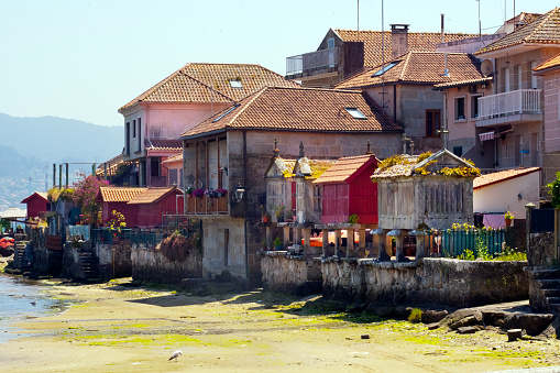 Hórreos de piedra y pueblo junto a la playa en Combarro, provincia de Pontevedra, Galicia, España photo
