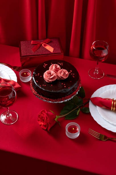 istock Romantic table setting with white dinnerware and red napkins, wine and candles. Valentines day or romantic dinner concept. Romantic Dinner. 1365081219