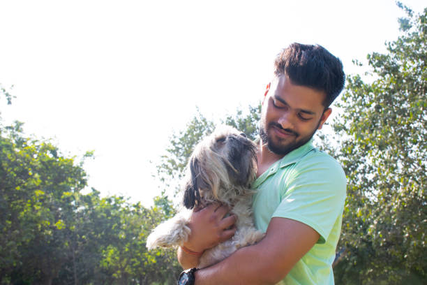 istock young man playing with dog at park 1365081527