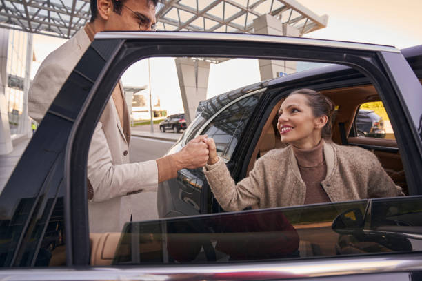 istock Woman exiting car with help of her partner 1365084215