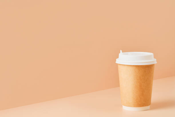 istock Paper unbranded glass for drinks with a white lid on a colored background, close-up with copy space for text.Cardboard eco-friendly coffee cup 1365085606