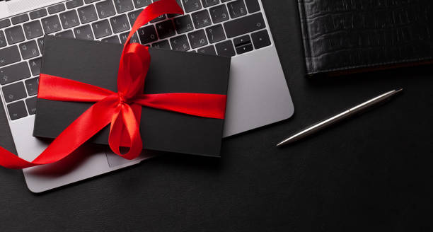 istock Gift box over laptop on office desk table 1365087637