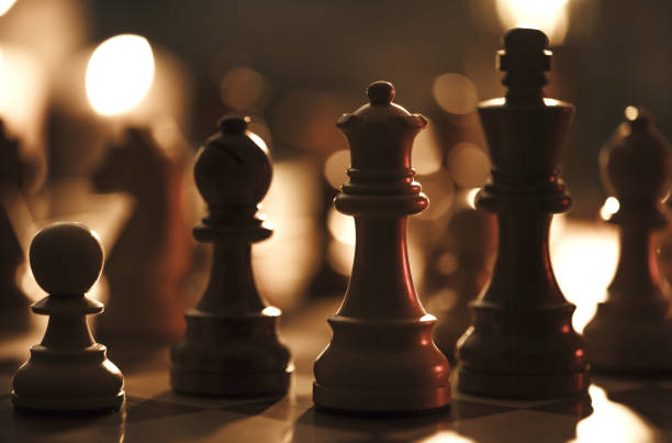 istock Wooden chess pieces on the chessboard and dim light 1365089948