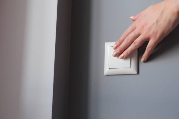 istock A beautiful female hand presses the switch on the wall 1365090503