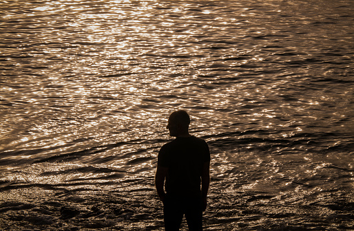 Portrait of adult man in jeans on beach. Almeria, Spain