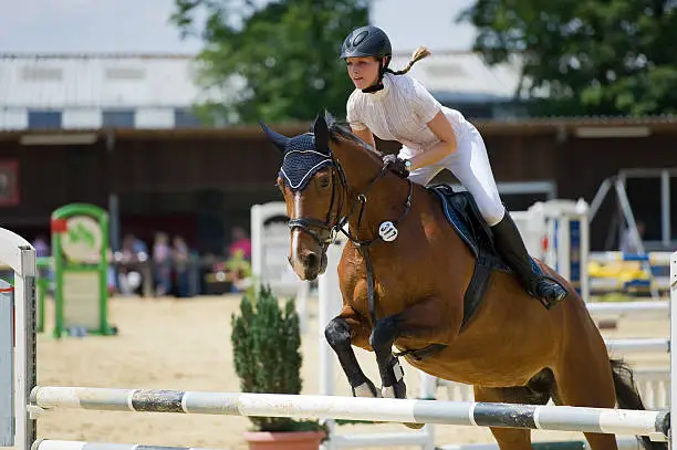 A woman is riding her horse