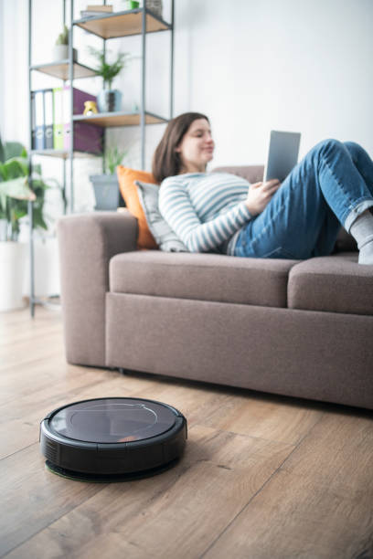 istock Pregnant woman having a break while robot vaccum is cleaning. 1365090881