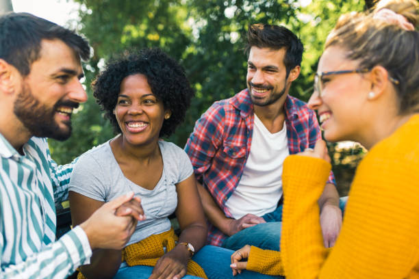 istock Woman with ear hearing problem having fun with her friends in the park 1365092426
