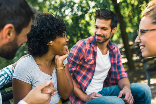 istock Woman with ear hearing problem having fun with her friends in the park 1365092428