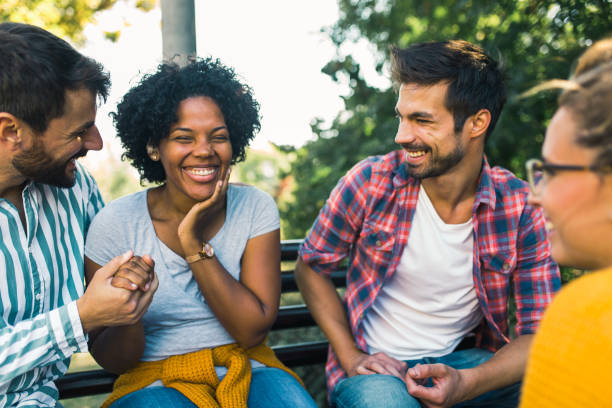 istock Woman with ear hearing problem having fun with her friends in the park 1365092429