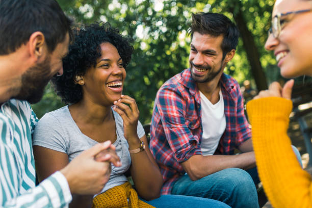 Woman with ear hearing problem having fun with her friends in the park stock photo