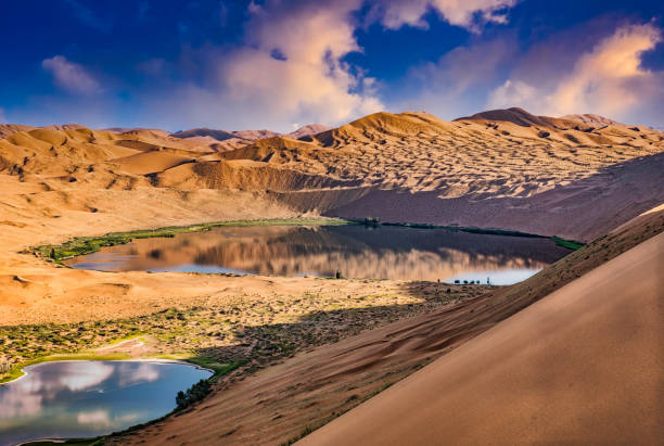 A tranquil and beautiful landscape with a couple of lakes reflecting the skies at the mysterious Badain Jaran Desert in Inner Mongolia, China