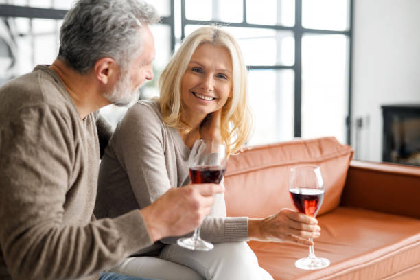 istock Harmonious mature married couple with wine having romantic date 1365095195