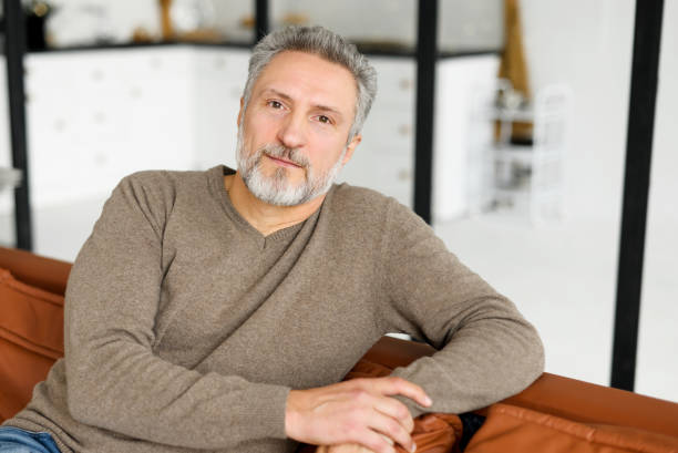 istock Good-looking handsome grey-haired mature man with a beard looks at camera 1365096631