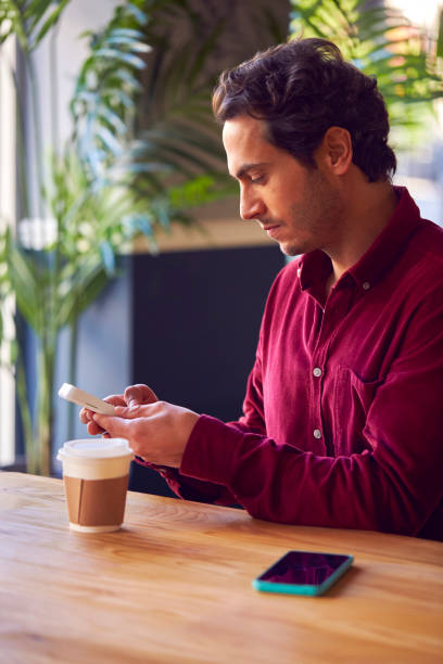 istock Man Making Contactless Purchase In Coffee Shop Using Debit Or Credit Card 1365100123