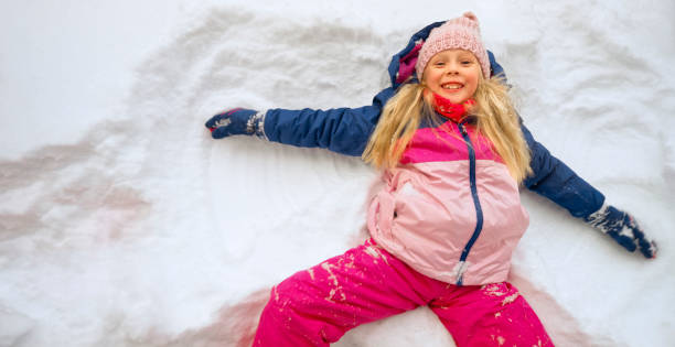 istock Girl lying on snow during winter 1365101860