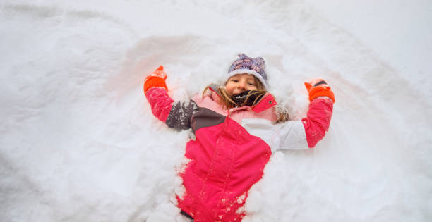 istock Girl lying on snow during winter 1365101869