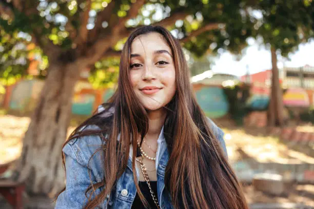 Photo of Adorable teenage girl looking at the camera outdoors