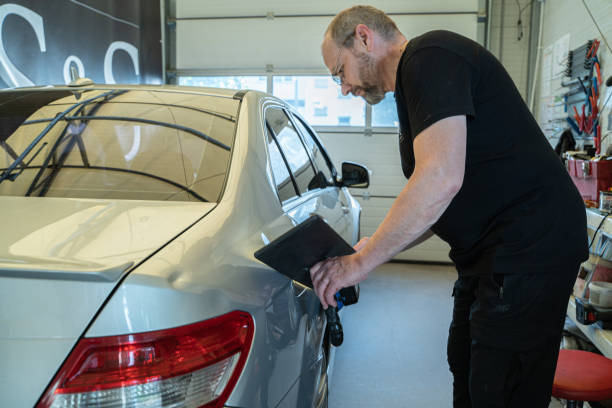 processus de réparation des bosses sur la carrosserie de la voiture. le technicien travaille à l’aide d’outils professionnels pour la réparation de bosses sans peinture. technologie pdr de carrosserie automobile - dented photos et images de collection