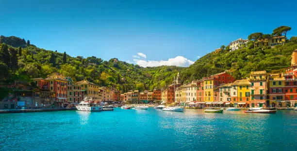 Portofino luxury travel destination. Village, yachts and boats in little marina. Liguria region, Italy