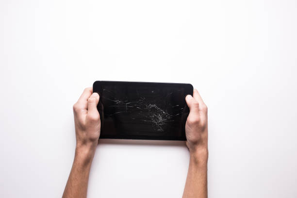 Black broken tablet on a white background. Cracked gadget screen. The guy holds a broken tablet in his hand Black broken tablet on a white background. Cracked gadget screen. The guy holds a broken tablet in his hand. broken digital tablet note pad cracked stock pictures, royalty-free photos & images