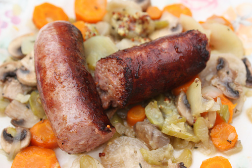 Diot sausages served with a stew of vegetables and mushrooms