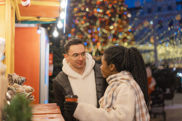 istock Couple on Christmas market buying drinks from stall 1365113068