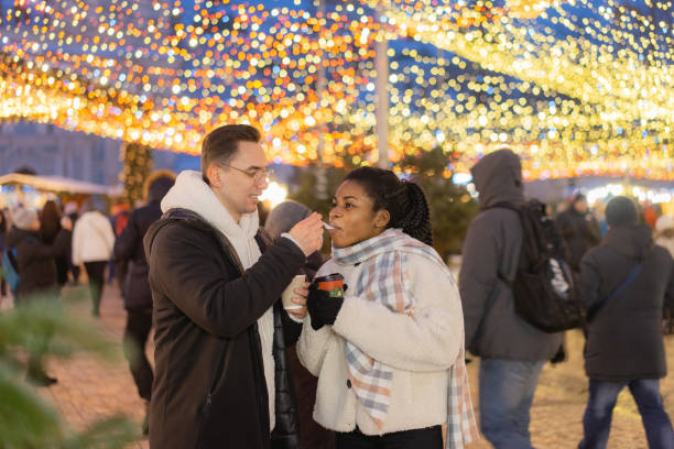 istock Couple sharing desert  on Christmas market 1365113072