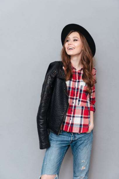 istock Woman posing with leather jacket over shoulder and looking away 1365116888