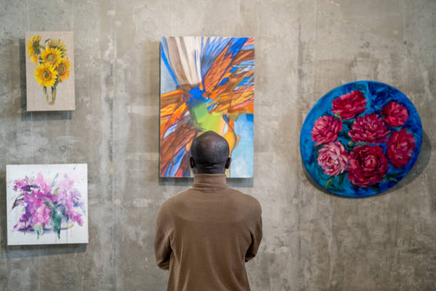 vista trasera del invitado masculino africano de la galería de arte de pie frente a la pared con exposiciones - galeria de arte fotografías e imágenes de stock