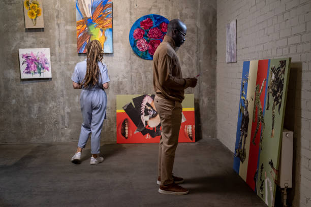 istock Young African man with leaflet standing in front of artwork 1365119181